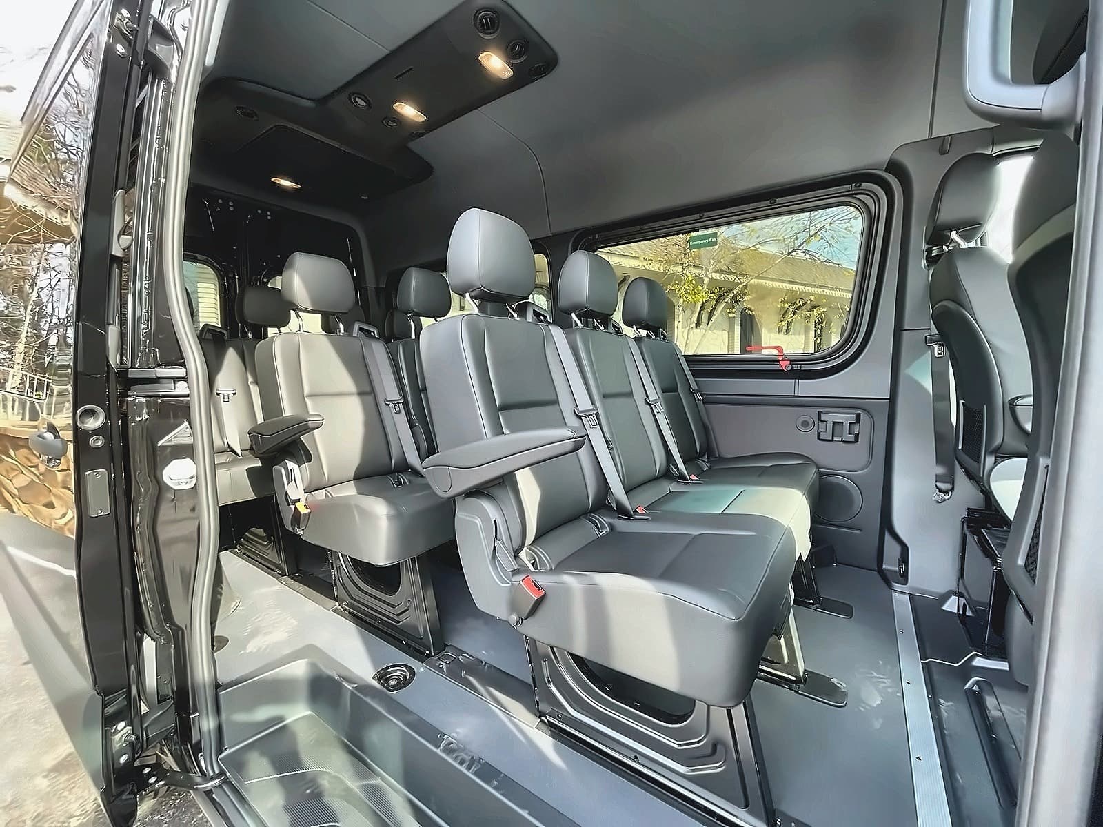 Inside TFSL's Mercedes Sprinter with every seat fitted: rows of grey seats with armrests either side of the aisle